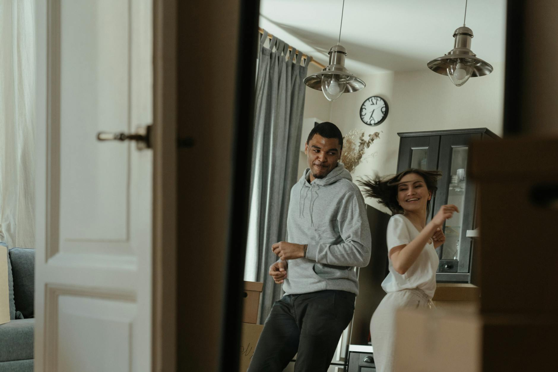Joyful couple dancing in their new apartment, celebrating a fresh start in life.