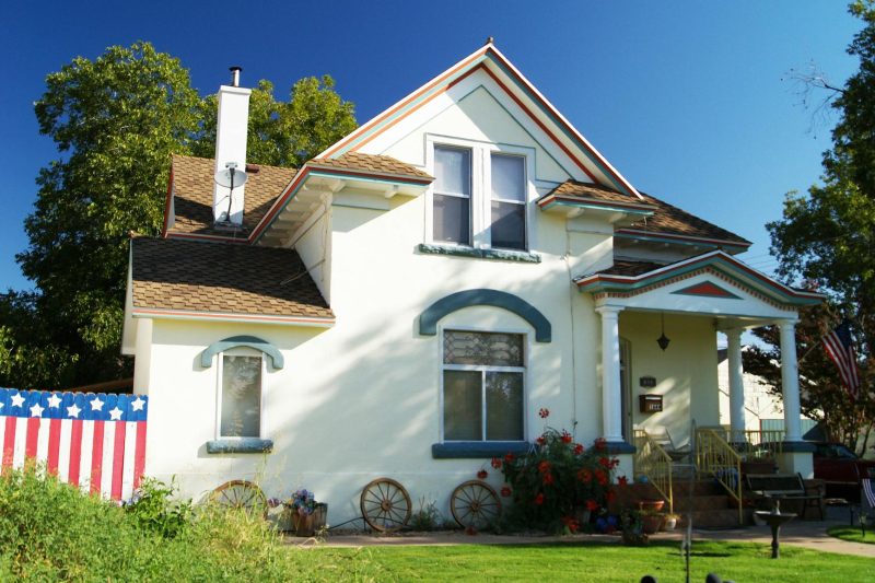 Suburban American house with a well-kept front yard and patriotic decorations.