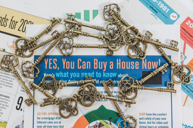Vintage keys scattered over real estate documents, representing property ownership and investment.